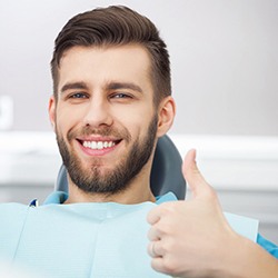 Handsome patient giving thumbs up for occlusal adjustment treatment