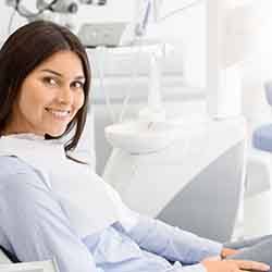 Woman leaning back in dental chair and smiling