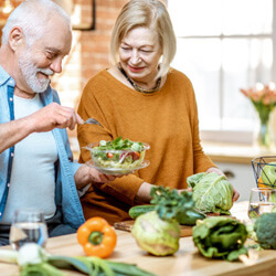 A cheerful senior couple eating healthy foods