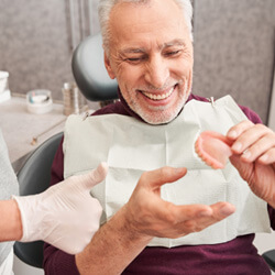 A dentist showing dentures to her patient